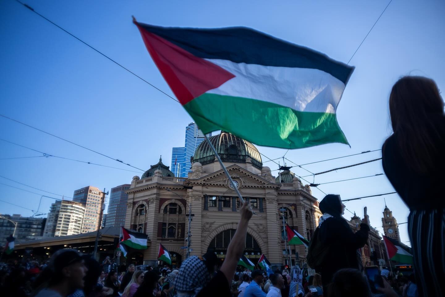 Palestine Flag flying in a rally outside Flinders St Station